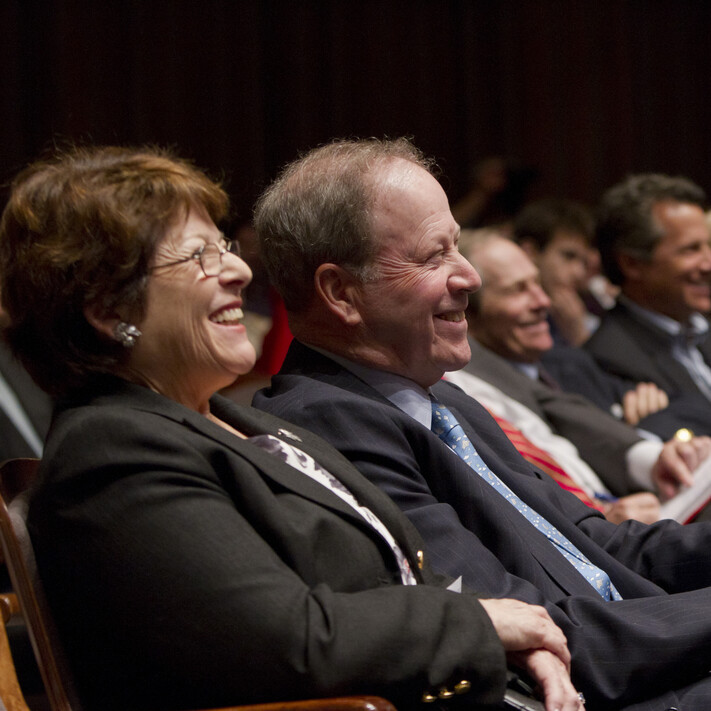 Lyn and Daavid Silfen laughing in the audience